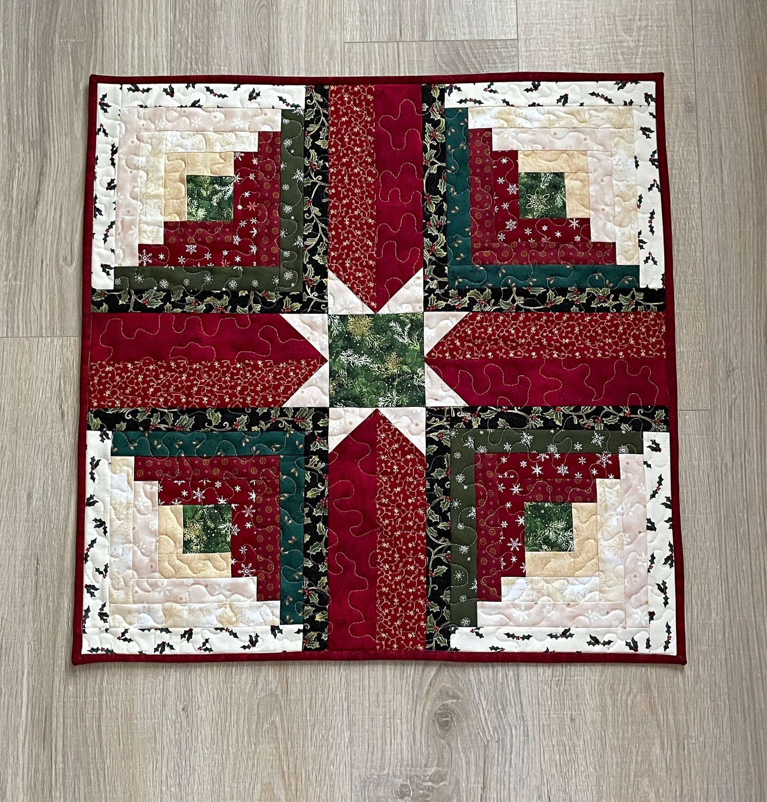 Christmas Log Cabin Star Table Topper in Red, Green and Cream.