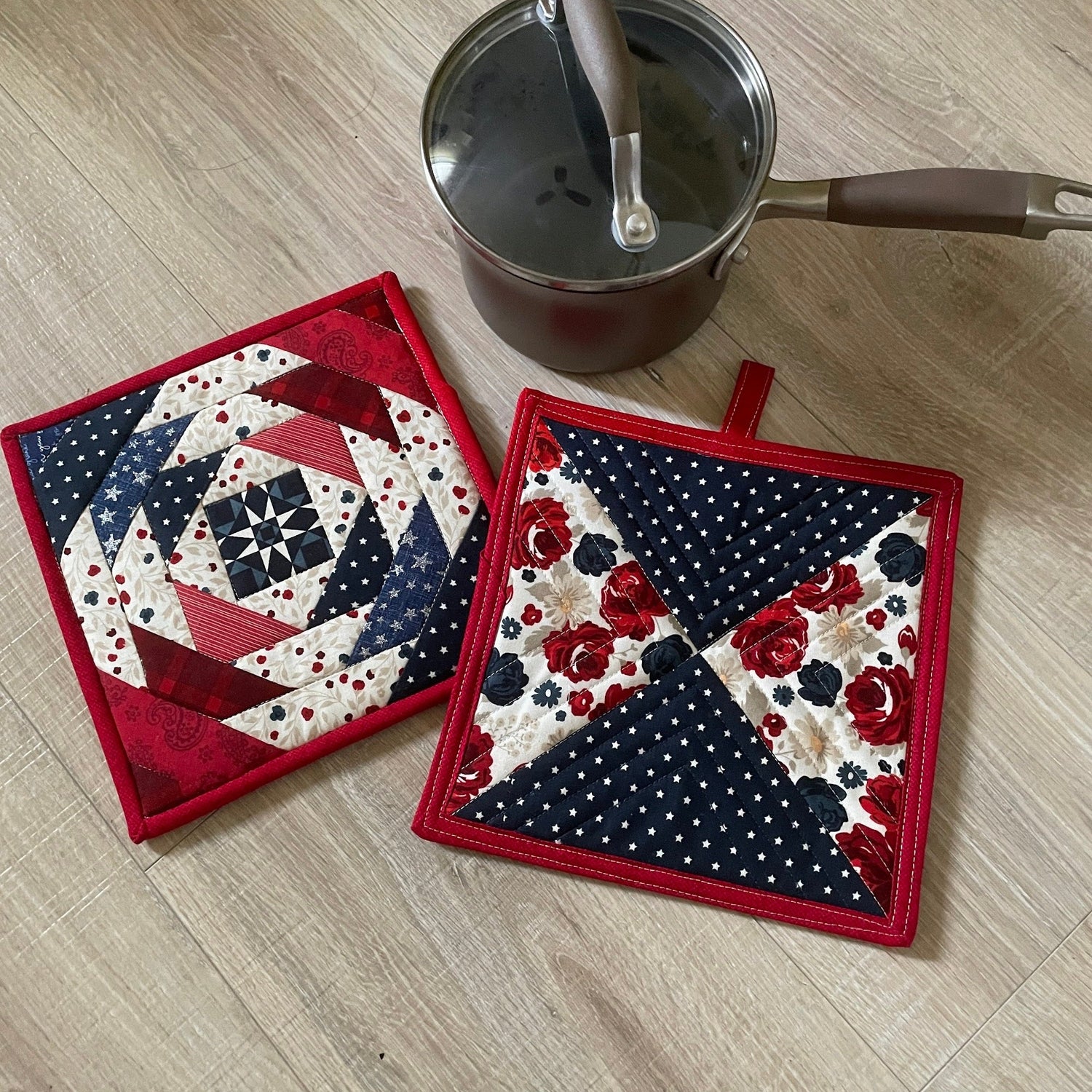 Set of two quilted potholders in red, white, and blue.