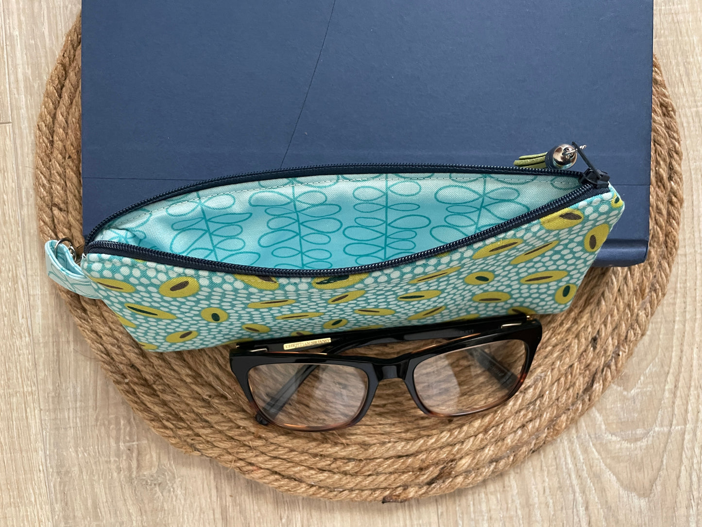 Blue and green retro oval print quilted eyewear case with zipper, leather tassel, and swivel hook