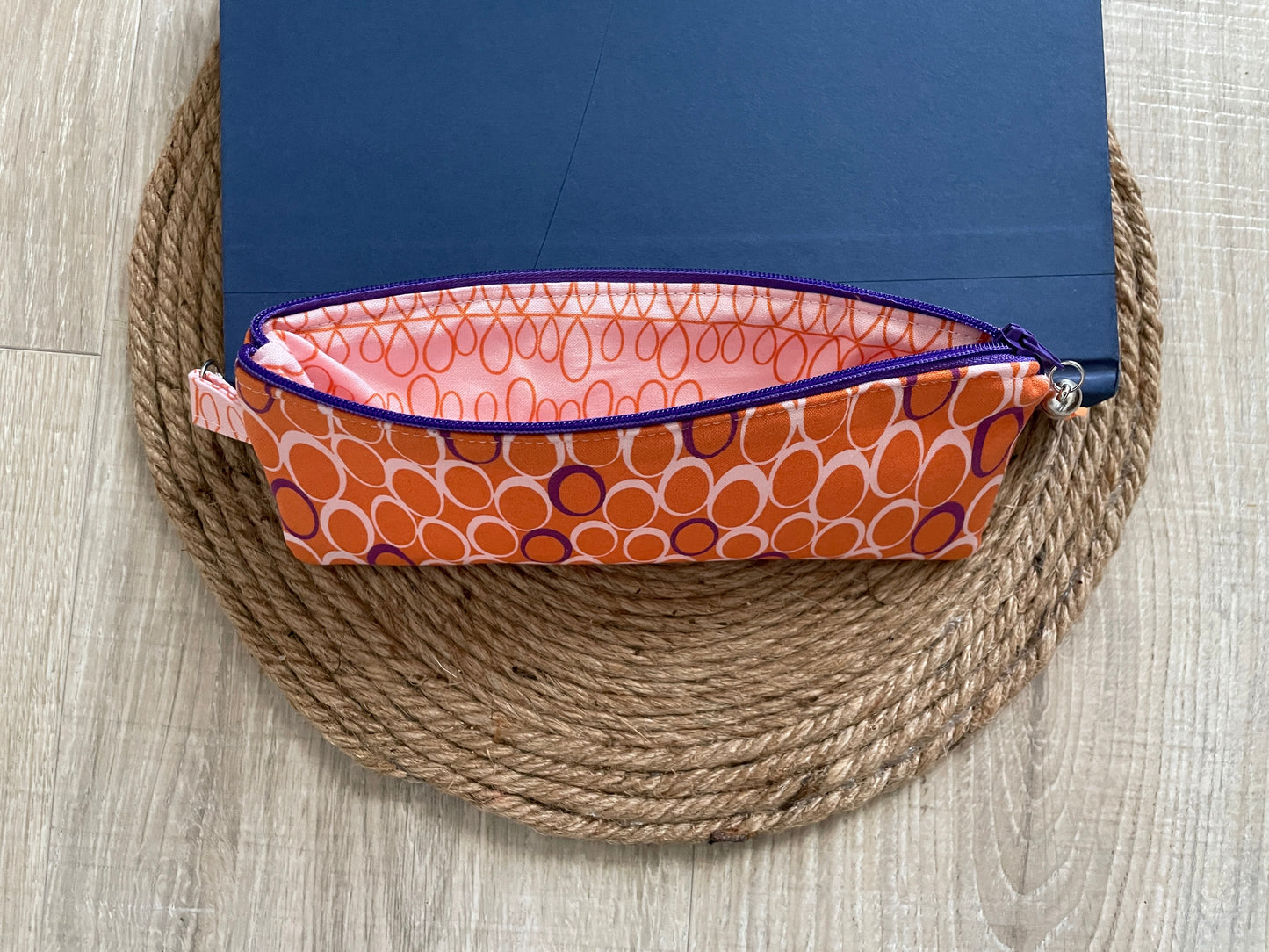 Pink, purple and orange retro dot print eyewear case with zipper and leather tassel.”