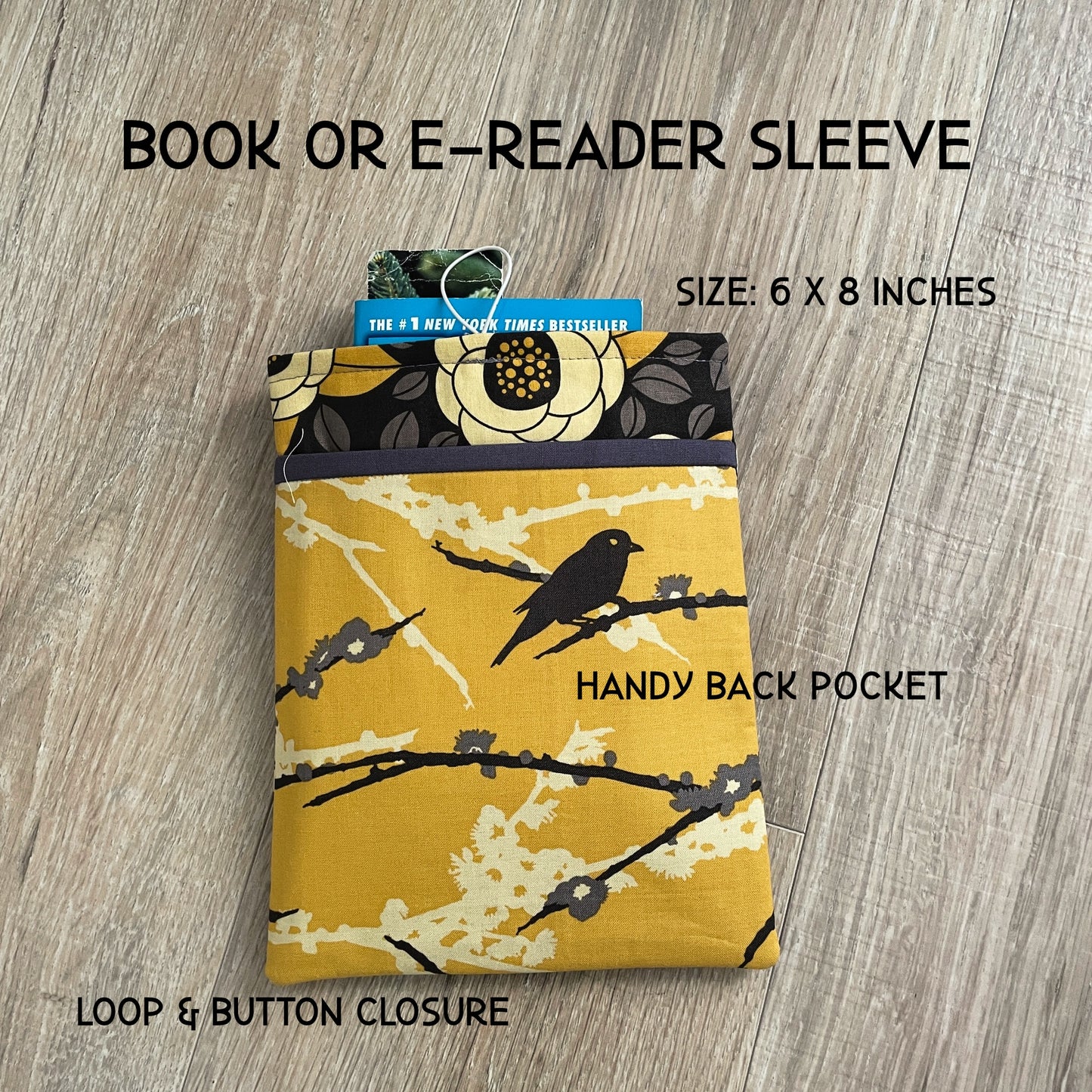 Handmade padded book sleeve featuring a vibrant yellow and gray modern floral fabric. Measures 6x8 inches with a handy back pocket with a button and elastic loop closure. Designed to fit Kindle Paperwhite or standard mass market paperbacks.
