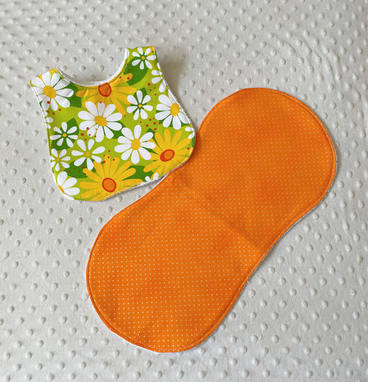 baby girl bib and burp cloth in orange and yellow featuring daisies