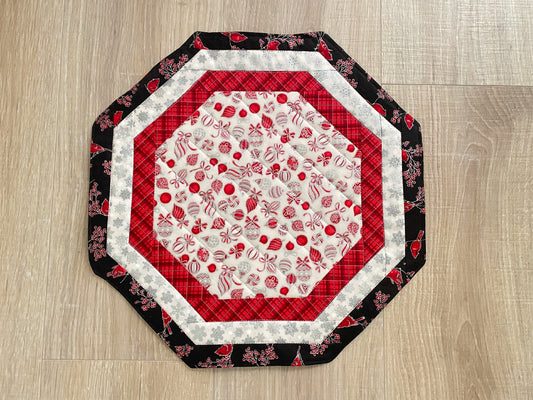 Quilted octagon Christmas table topper with red, white, black, and silver holiday fabrics