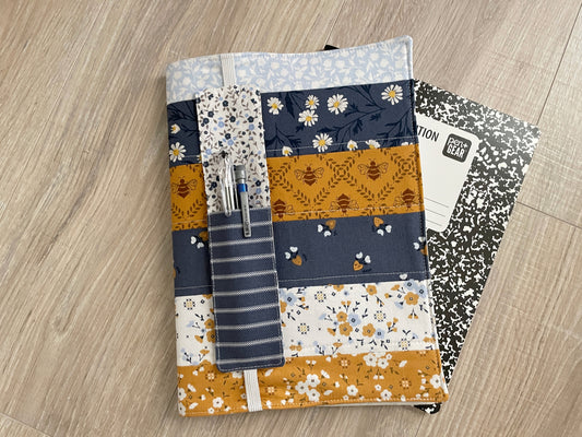 Handmade blue, white, and yellow patchwork notebook cover featuring front pen pockets