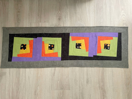 Halloween quilted table runner with bright wonky log cabin blocks