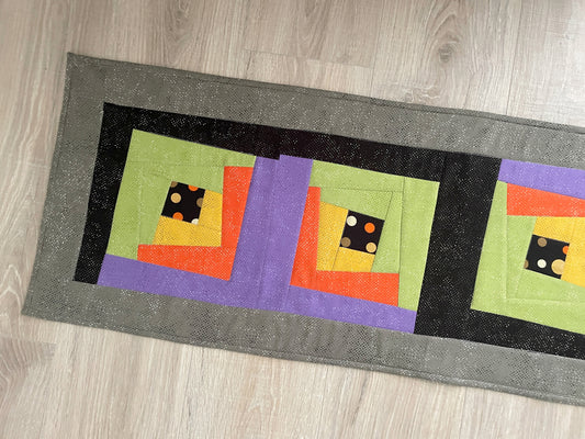 Halloween quilted table runner with bright wonky log cabin blocks