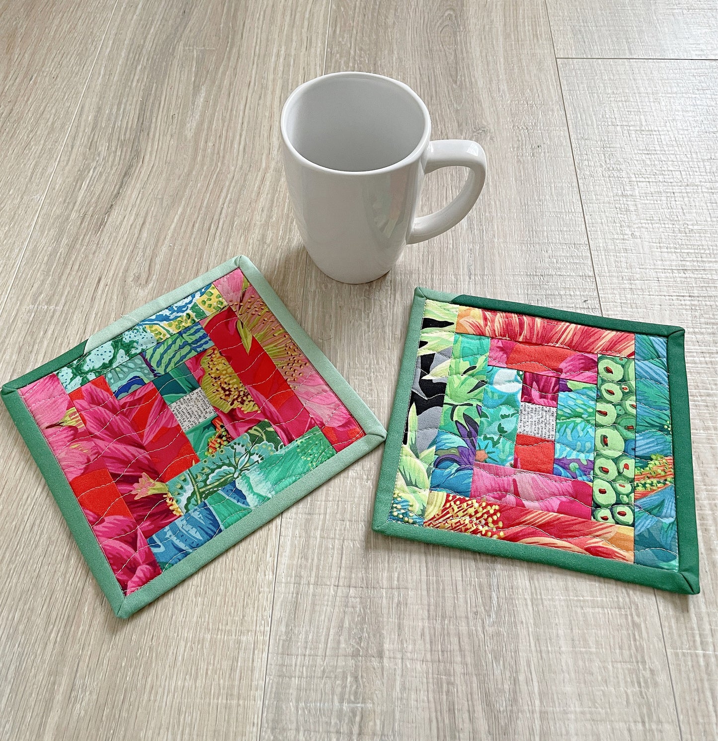 set of two brightly colored fabric mug rugs in pink and green.
