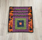 Set of four Halloween quilted placemats with courthouse‑steps quilt block design