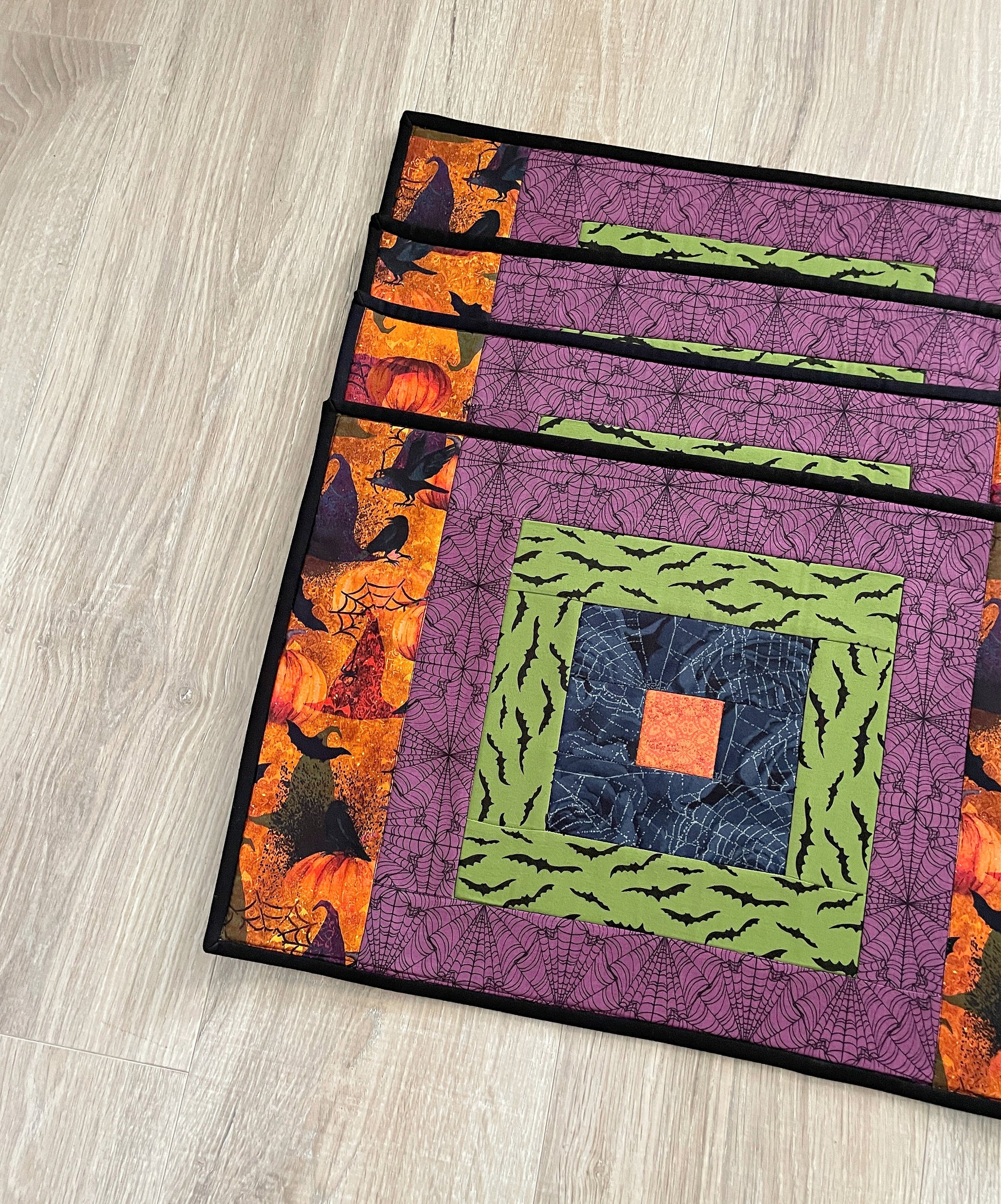 Set of four Halloween quilted placemats with courthouse‑steps quilt block design