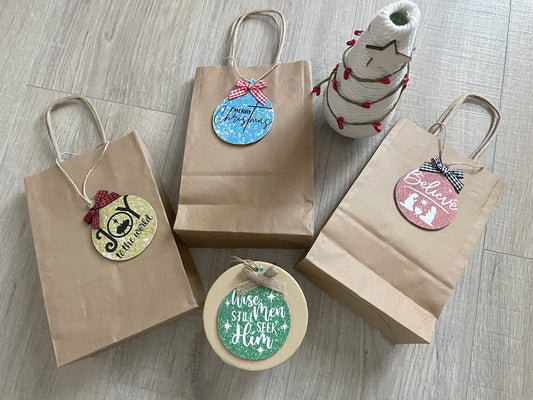 Set of four round wooden ornament tags reading Joy to the World, Merry Christmas, Believe, and Wise Men Still Seek Him