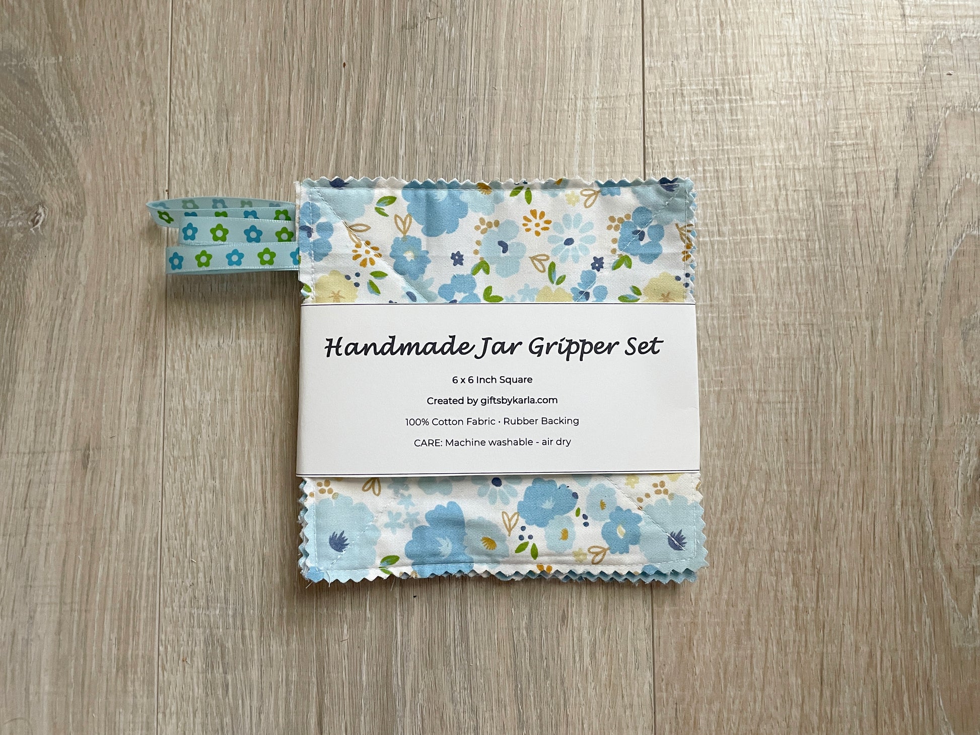 Blue floral handmade fabric jar gripper set of three with non-slip backing and ribbon loops for opening stubborn jar lids