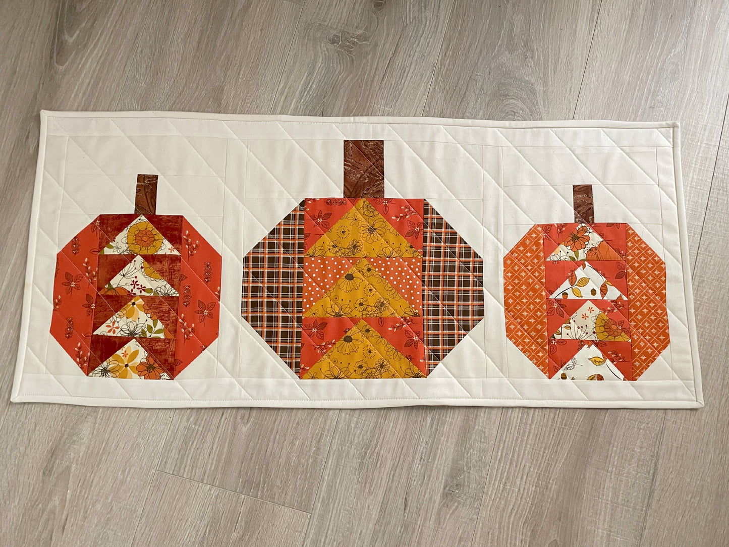 Autumn quilted table decor featuring flying geese pumpkin blocks