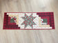 Quilted Christmas table runner with Log Cabin and Star blocks in red, white, and green