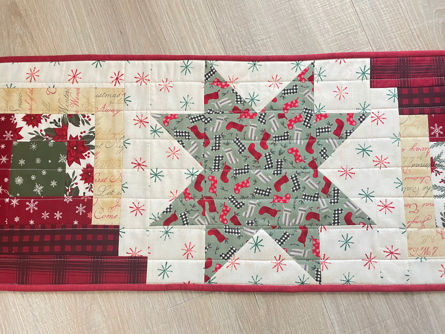 Quilted Christmas table runner with Log Cabin and Star blocks in red, white, and green