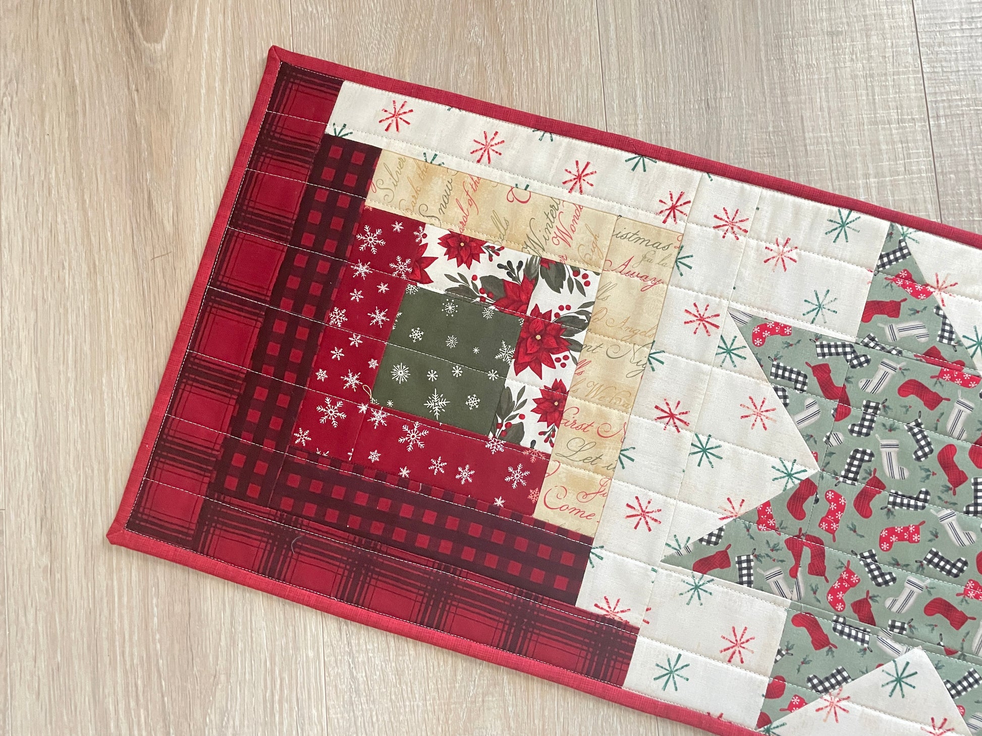 Quilted Christmas table runner with Log Cabin and Star blocks in red, white, and green