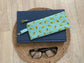 Blue and green retro oval print quilted eyewear case with zipper, leather tassel, and swivel hook