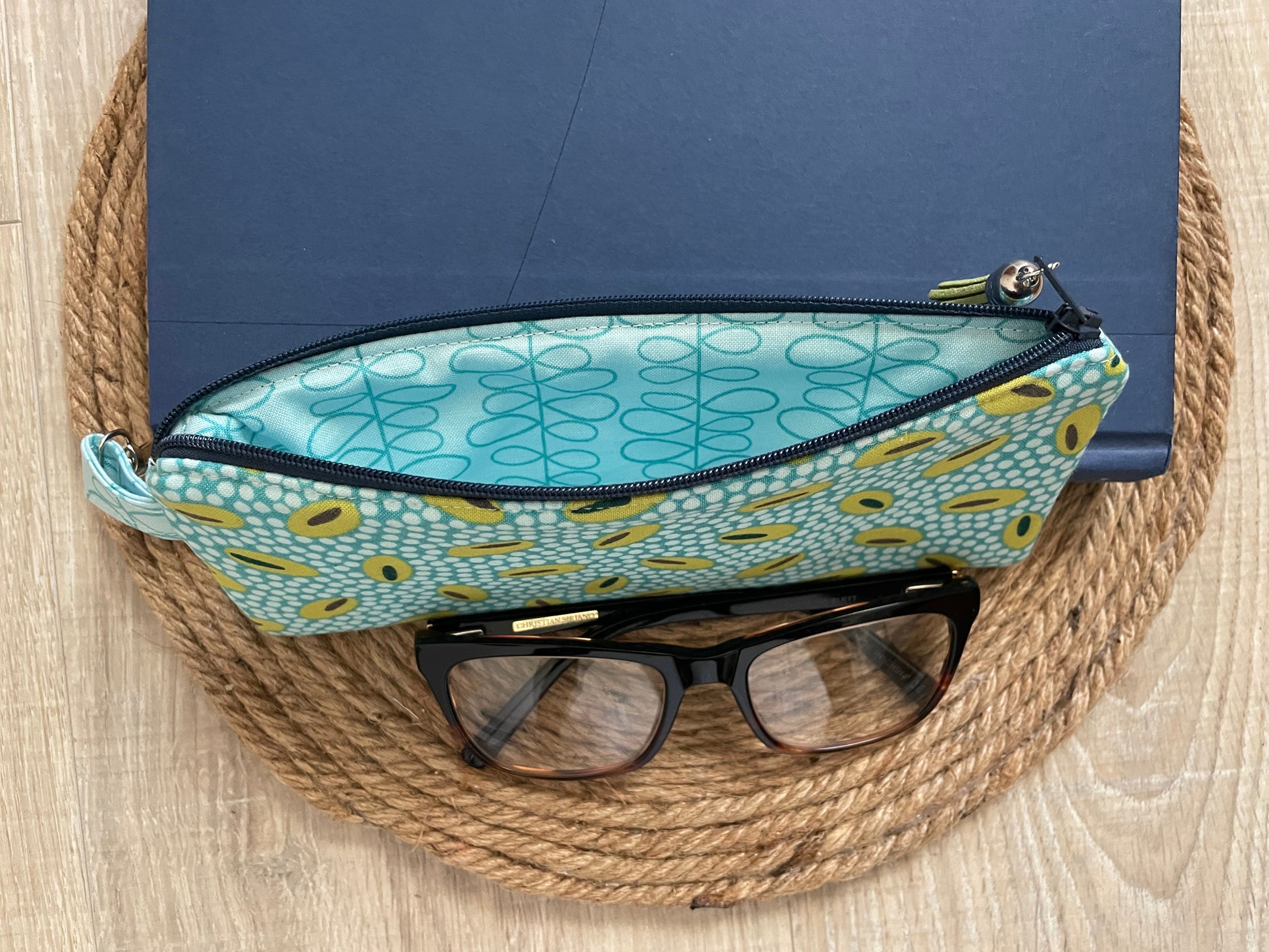 Blue and green retro oval print quilted eyewear case with zipper, leather tassel, and swivel hook