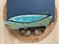 Blue and green retro oval print quilted eyewear case with zipper, leather tassel, and swivel hook