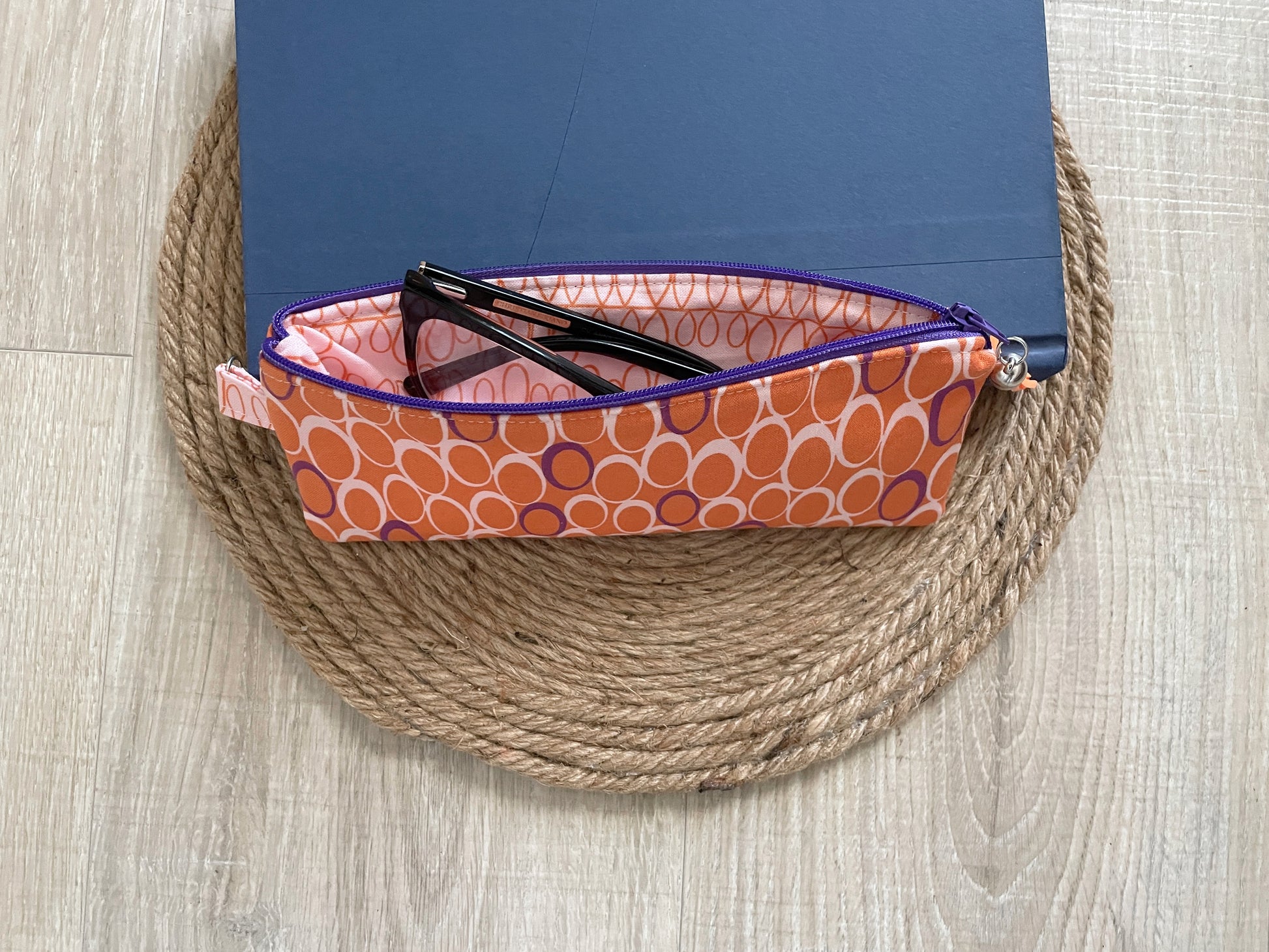 Pink, purple and orange retro dot print eyewear case with zipper and leather tassel.”