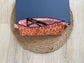 Pink, purple and orange retro dot print eyewear case with zipper and leather tassel.”
