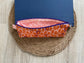 Pink, purple and orange retro dot print eyewear case with zipper and leather tassel.”