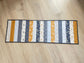 Quilted table runner with floral and bee prints in blues and golds