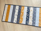 Quilted table runner with floral and bee prints in blues and golds