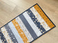 Quilted table runner with floral and bee prints in blues and golds
