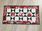 Handmade quilted Christmas table runner in red and green Hustle & Bustle fabric by Basic Grey, 13x26 inches.