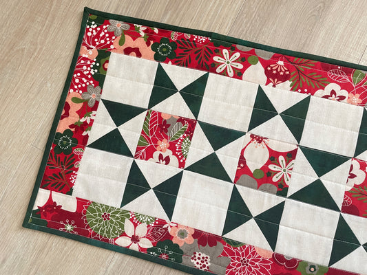 Handmade quilted Christmas table runner in red and green Hustle & Bustle fabric by Basic Grey, 13x26 inches.