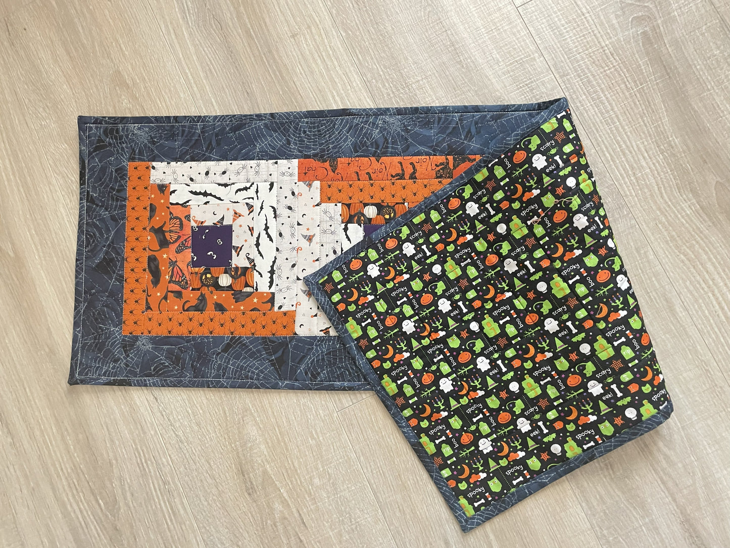 Scrappy Halloween quilted table runner with pumpkins, cats, and witchy prints