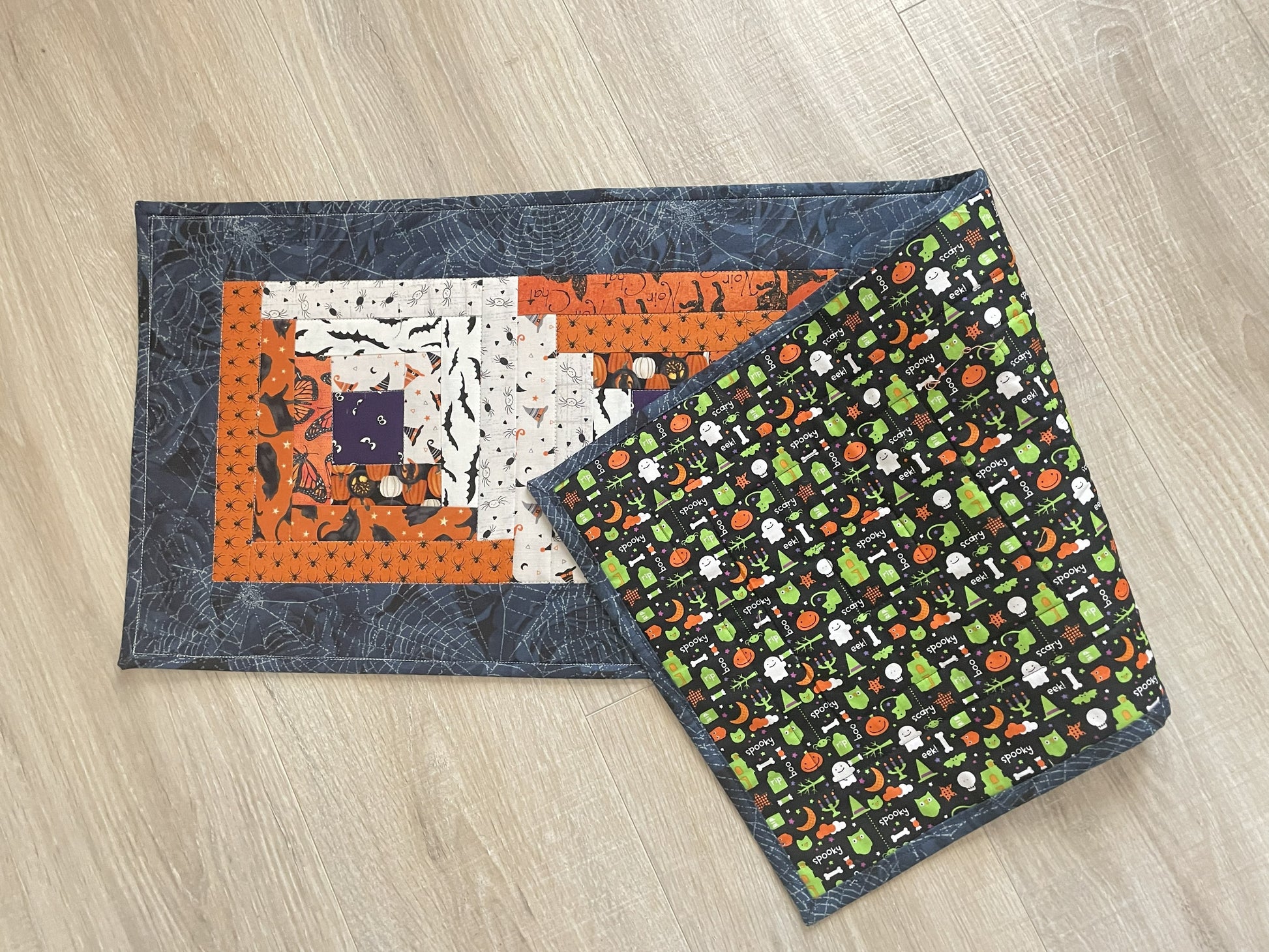 Scrappy Halloween quilted table runner with pumpkins, cats, and witchy prints