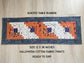 Scrappy Halloween quilted table runner with pumpkins, cats, and witchy prints