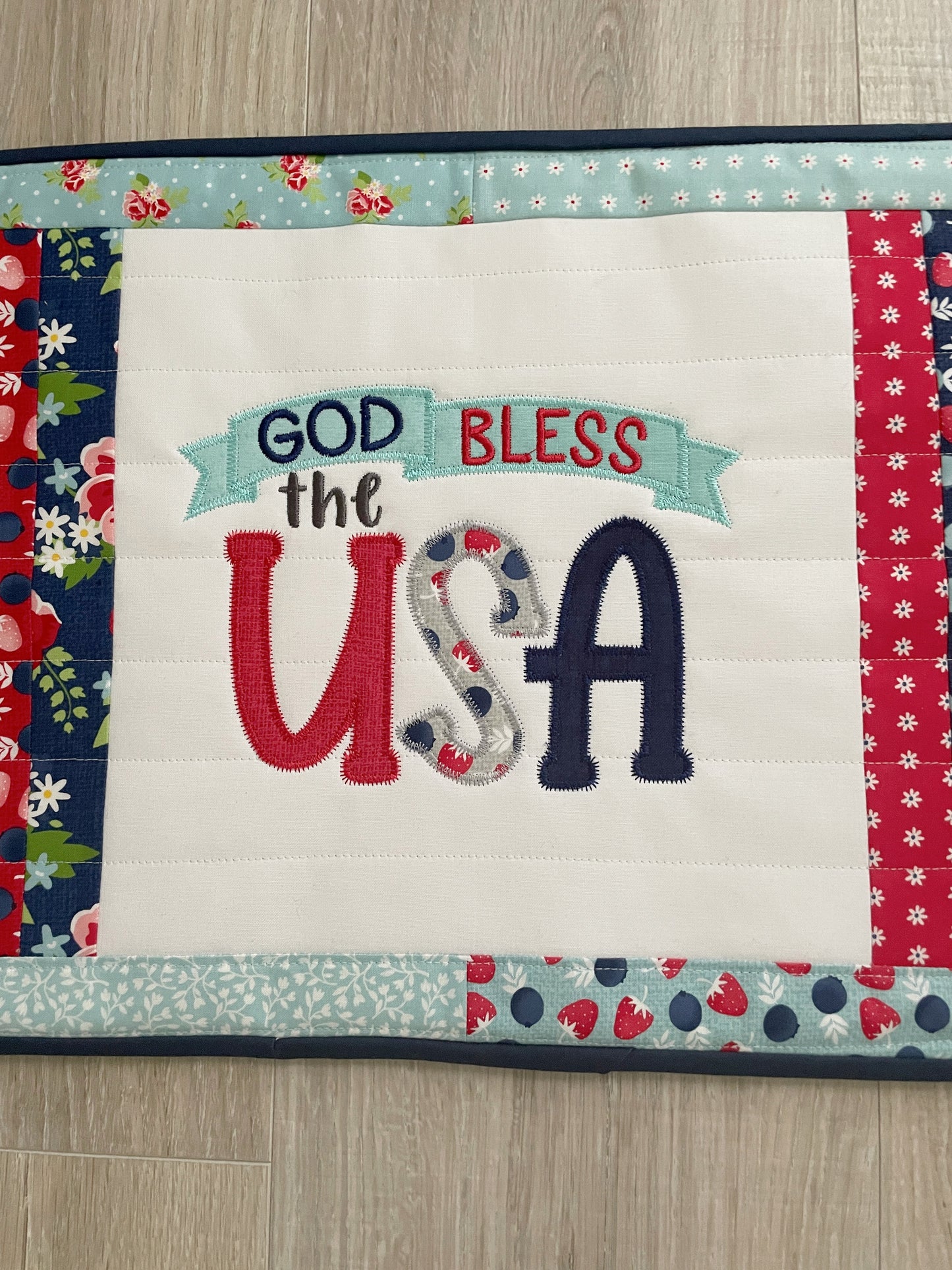 This 12 x 16 red, white, and blue quilted casserole hot pad/trivet has a scrappy patchwork center panel featuring a machine embroidered design -- God Bless the USA. These are perfect for a 9 x 13 casserole dish or 2 smaller baking dishes.