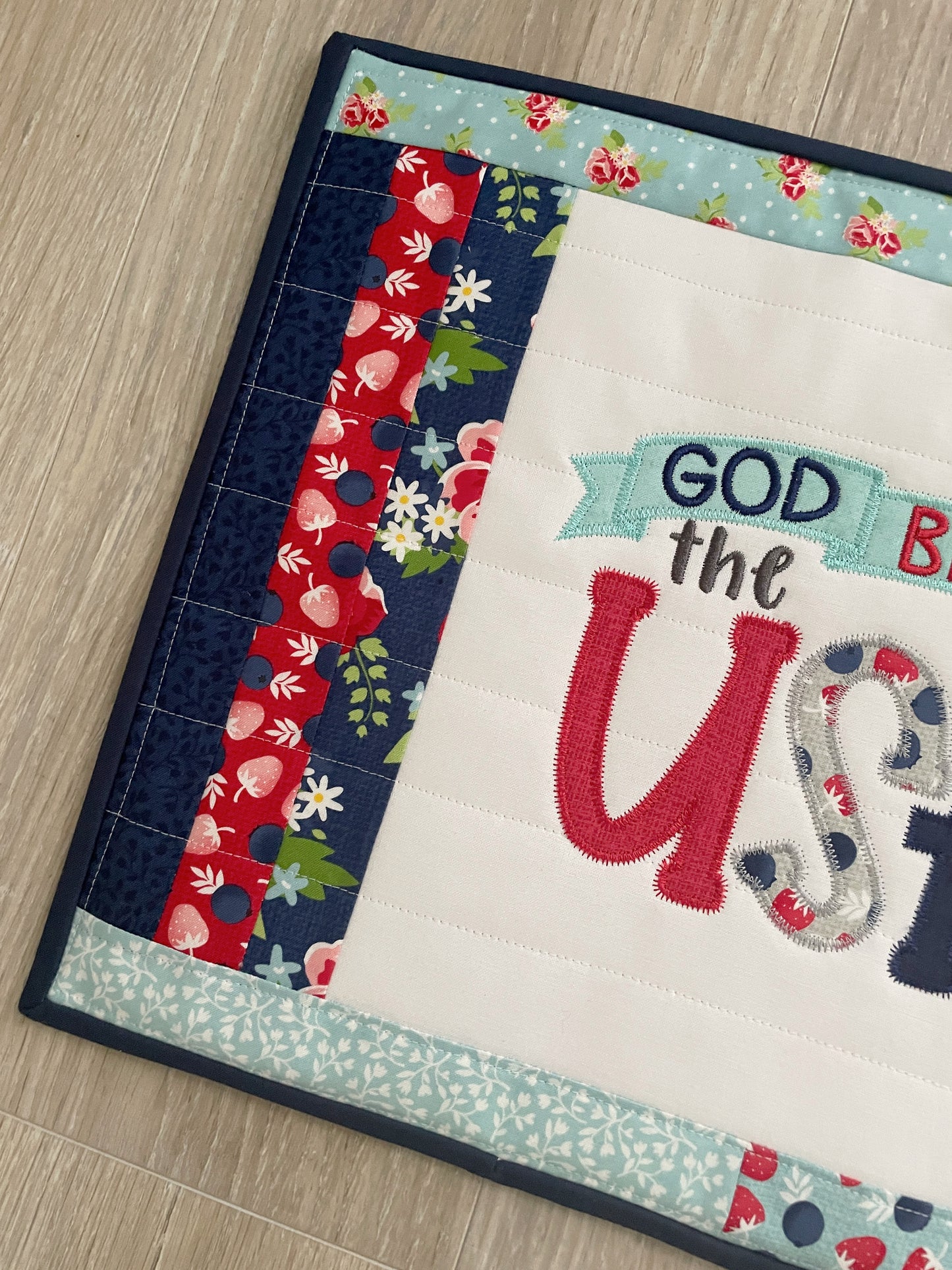 This 12 x 16 red, white, and blue quilted casserole hot pad/trivet has a scrappy patchwork center panel featuring a machine embroidered design -- God Bless the USA. These are perfect for a 9 x 13 casserole dish or 2 smaller baking dishes.