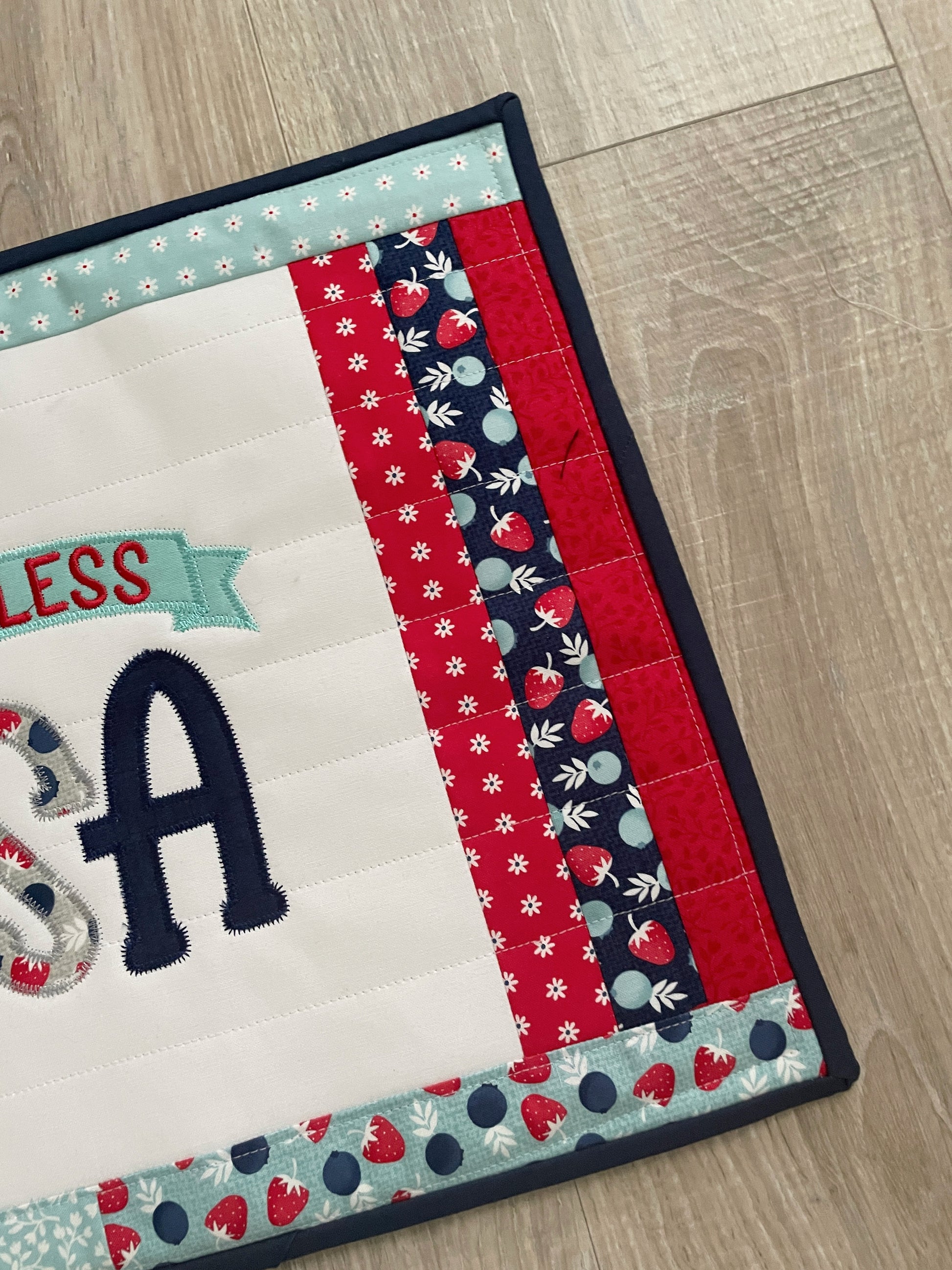 This 12 x 16 red, white, and blue quilted casserole hot pad/trivet has a scrappy patchwork center panel featuring a machine embroidered design -- God Bless the USA. These are perfect for a 9 x 13 casserole dish or 2 smaller baking dishes.