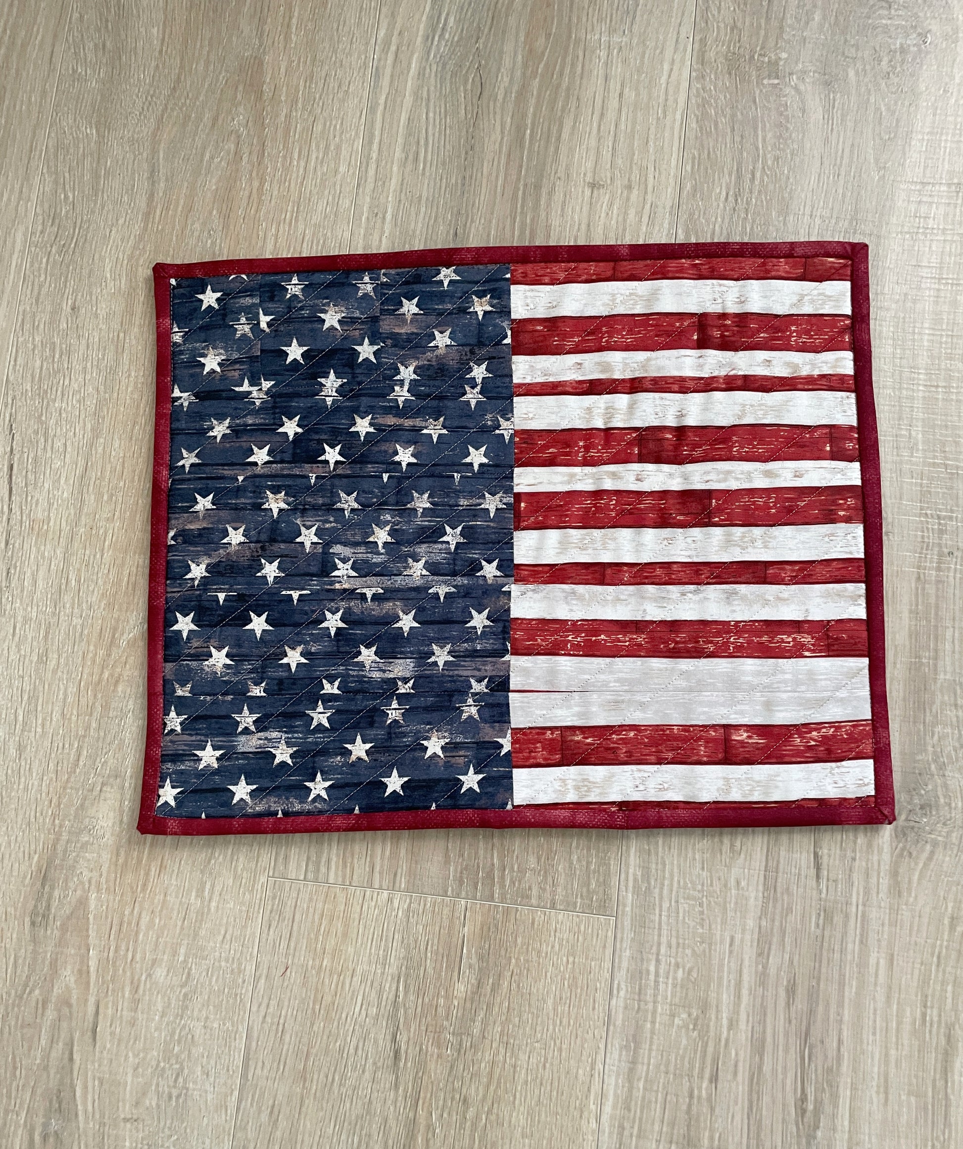 This lovely red, white, and blue quilted casserole hot pad makes your table beautiful! Measuring 13 x 16 inches, this handmade kitchen trivet features a scrappy improv patchwork resembling the American Flag, making it perfect for a 9 x 13 casserole dish or 2 smaller baking dishes.