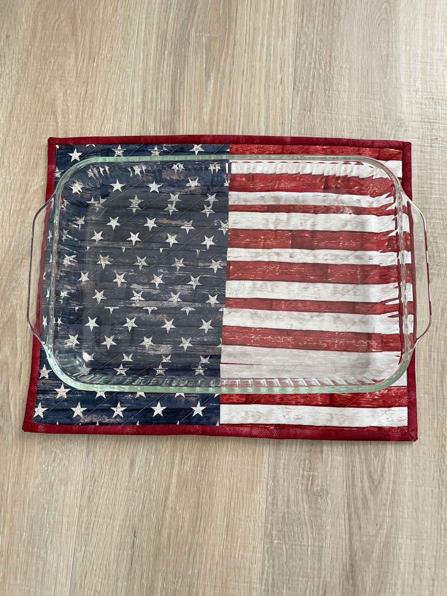 This lovely red, white, and blue quilted casserole hot pad makes your table beautiful! Measuring 13 x 16 inches, this handmade kitchen trivet features a scrappy improv patchwork resembling the American Flag, making it perfect for a 9 x 13 casserole dish or 2 smaller baking dishes.