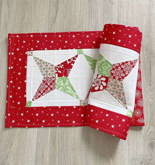 Quilted Christmas table runner in red, green, and white. Modern take on the star quilt block.