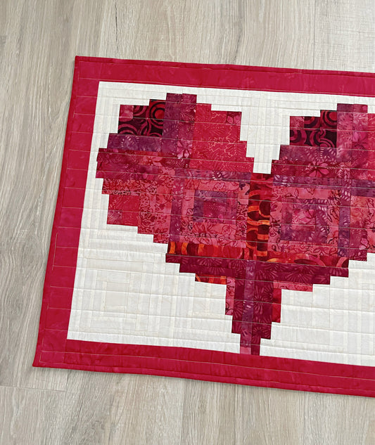 heart shaped log cabin quilted table runner  in red and pink batik fabrics.