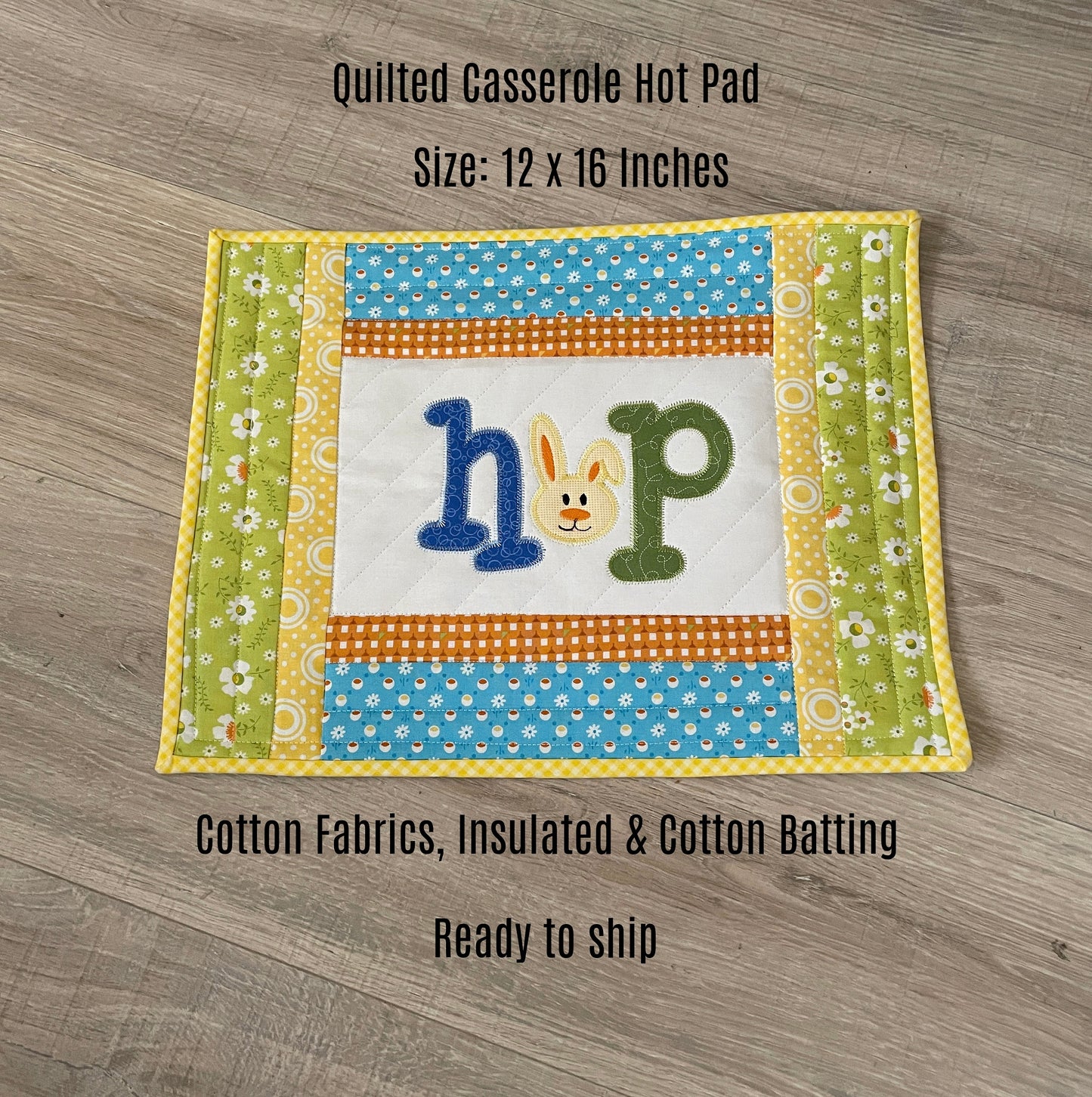 quilted casserole hot pad in green blue and yellow with embroidery design in the center panel